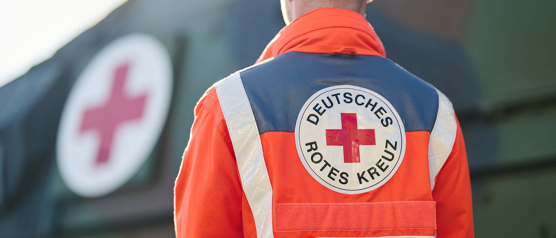 DRKler vor Bundeswehrfahrzeug