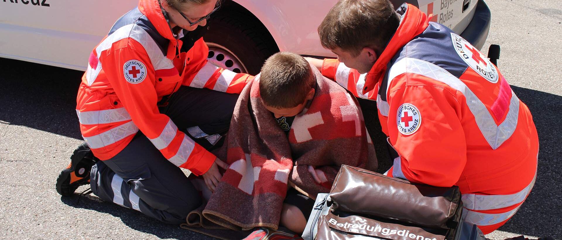 Bevölkerungsschutz und Rettung DRKlerin und DRKler versorgen Jungen