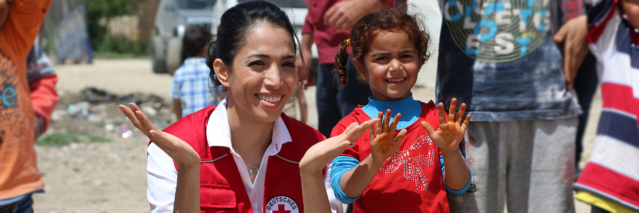 Foto: Zohre Esmaeli und ein syrisches Mädchen zeigen ihre Hände