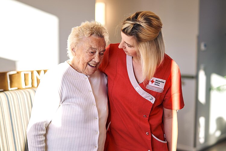 DRK-Pflegerin begrüßt Seniorin
