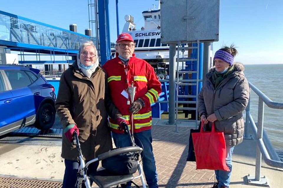 Am Fähranleger in Wyk auf der Nordseeinsel Föhr übernahm der Vorsitzende des DRK-Ortsvereins Wyk auf Föhr, Helmut Marczinkowski, die Fackel aus der Hand von Traute Diekmann (li.) und Birte Olufs (re.).