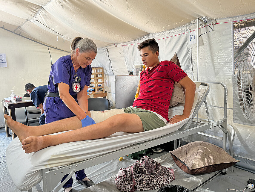 Rotkreuzmitarbeiterin behandelt Patienten im Feldkrankenhaus 