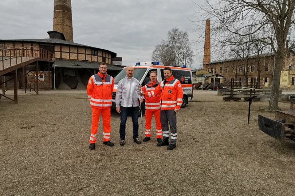 Patrick Herrmann (Mitglied der SEE-Sanität), Ziegeleipark-Leiter Roy Lepschies, Hendrik Janz (Kreisbereitschaftsleiter DRK-Kreisverband Ostprignitz-Ruppin) und Ronny Schüler (Bereitschaftsleiter SEE-Sanität DRK-Kreisverband Gransee e.V.) mit der Fackel im Ziegelpark Mildenberg