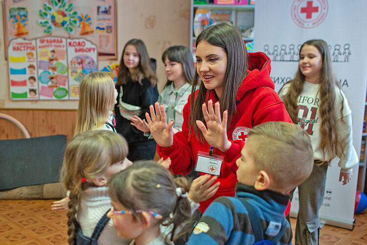 Rotkreuzhelferin und Kinder in der Ukraine