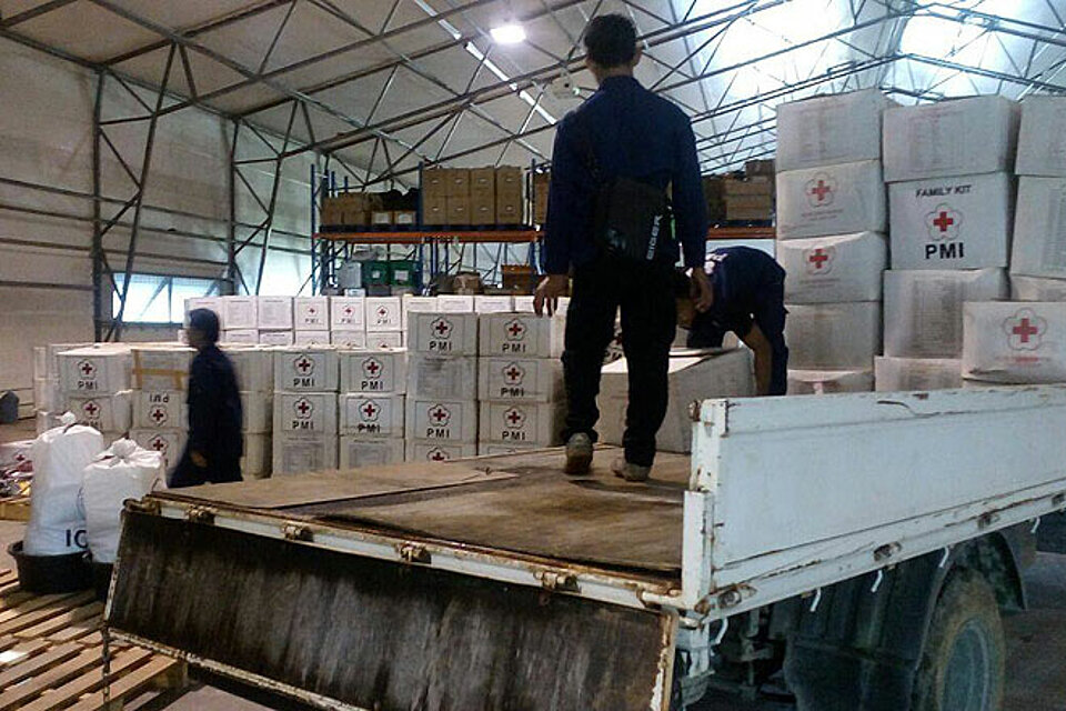 LKWs werden vom Indonesischen Roten Kreuz mit Hilfsgütern beladen..
