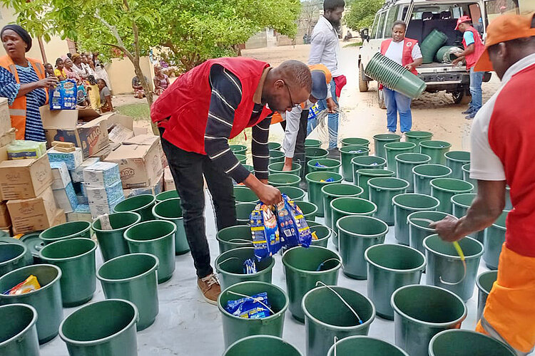 Helfer des Mosambikanischen Roten Kreuzes mir Hilfsgütern 