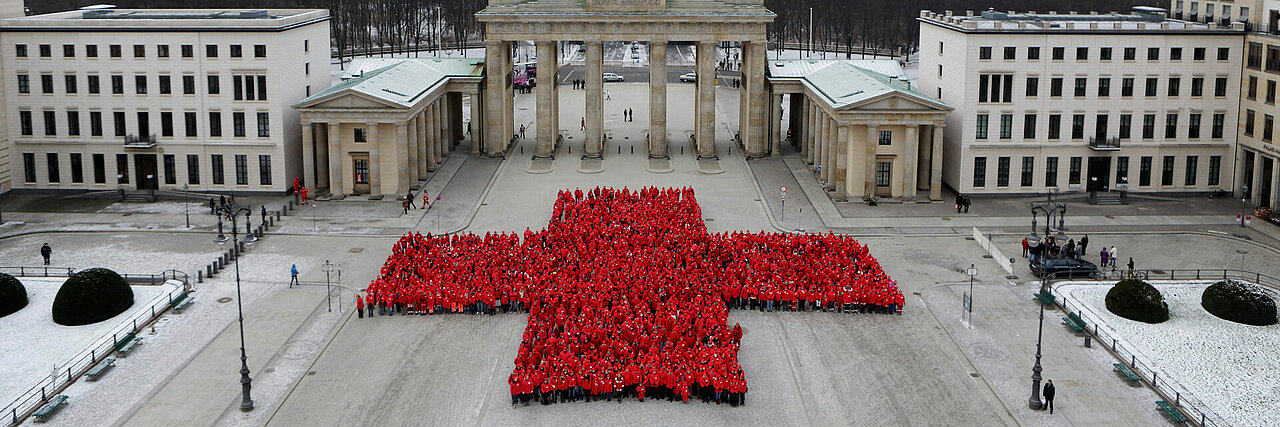 Hunderte DRK-Mitarbeiter formen ein Rotes Kreuz am Brandenburger Tor