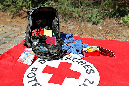 Rucksack auf DRK-Decke mit lebenswichtigen Dingen