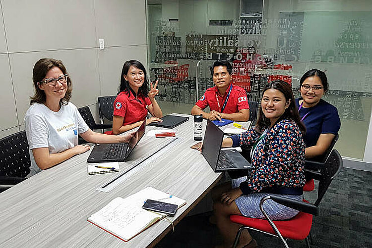 Foto: Rotkreuzlerinnen aus Deutschland und den Philippinenen an einem Tisch
