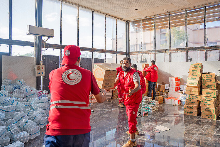 Helfer des Libyschen Roten Halbmondes mit Hilfsgütern 