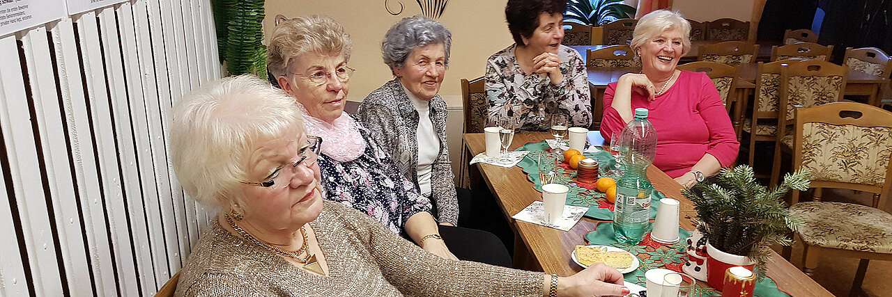 Senioren lachen am geschmückten Tisch
