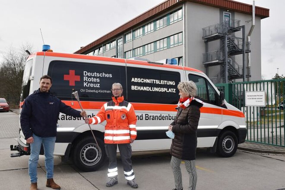 Ehrenamtliche des DRK OV Doberlug-Kirchhain vor einem Einsatzfahrzeug