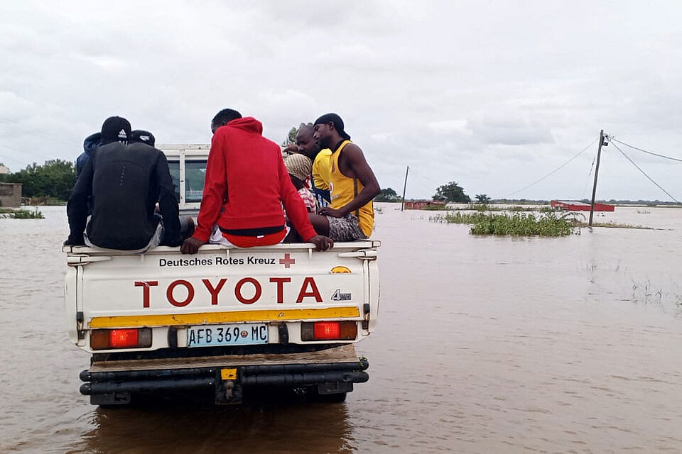 Menschen auf Lagefläche eines DRK-Pickups