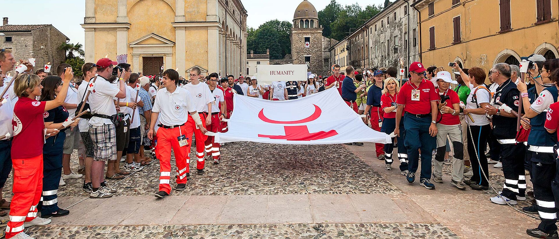 Fackelzug, Helfer tragen Transparent mit Schutzsymbolen
