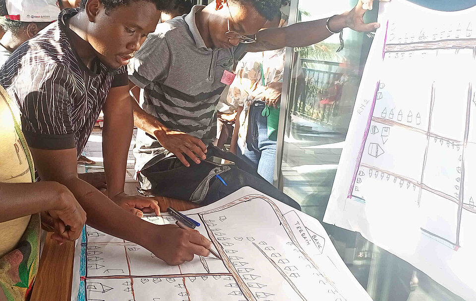 Katastrophenvorsorge in Madagaskar Bewohner und Rotkreuzmitarbeiter und -Freiwillige arbeiten zusammen an einem Tisch