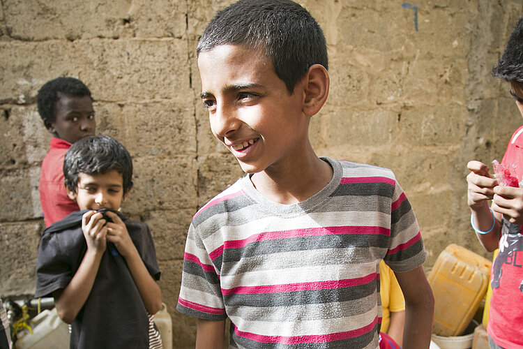 Junge an Wasserstelle im Jemen