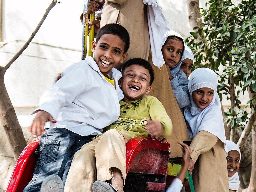 DRK hilft Kindern im Jemen: Kinder auf Klettergerüst lachen