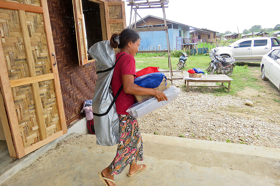 Frau aus Myanmar trägt Rotkreuz-Hilfsgüter 