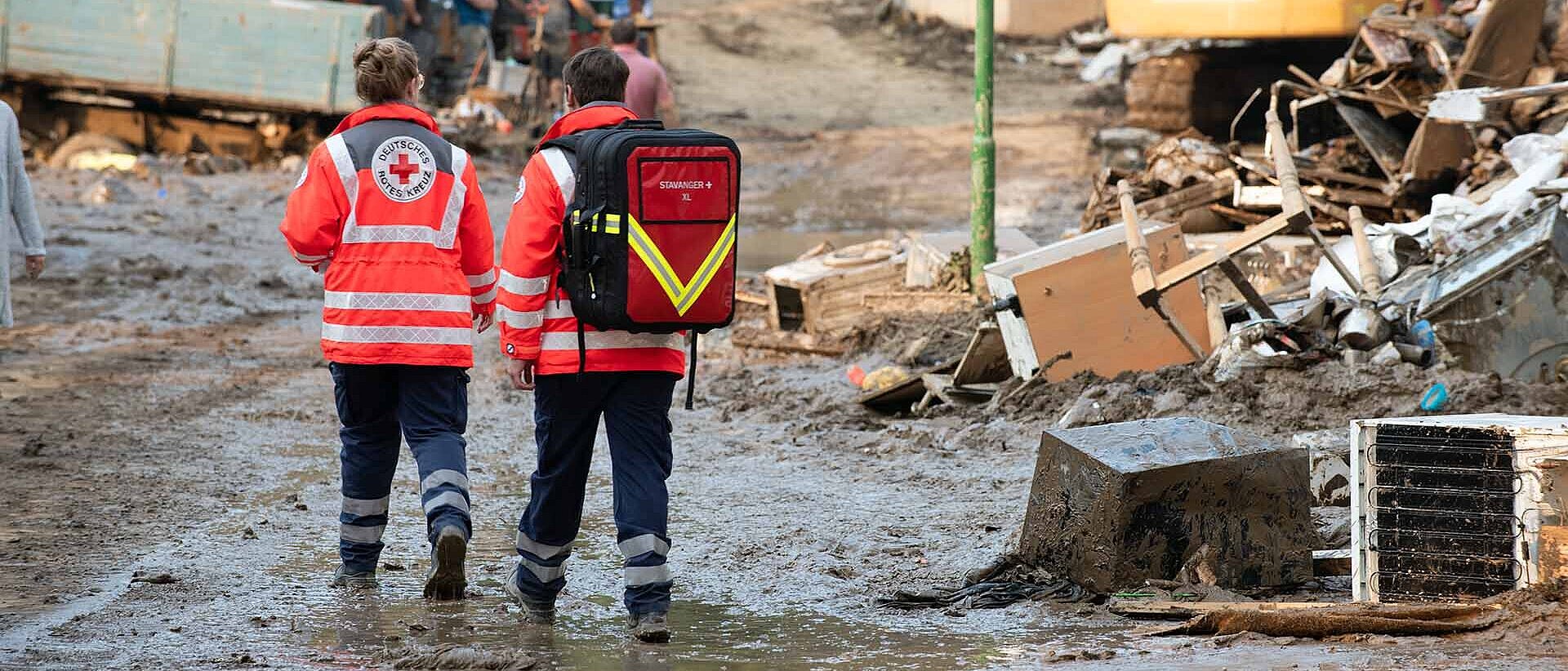 Zwei DRK-Einsatzkräfte zu Fuß im Hochwassergebiet