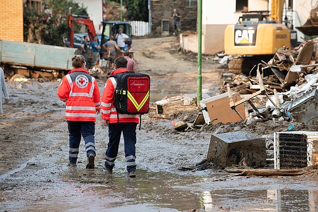 Zwei DRK-Einsatzkräfte zu Fuß im Hochwassergebiet