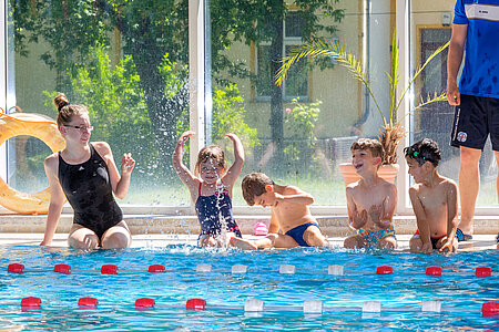 Kinder lernen in einem Kurs der Wasserwacht Schwimmen.