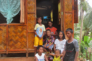 Philippinische Familie vor ihrem Haus