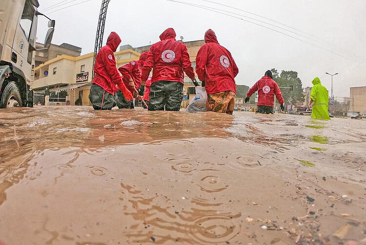 Fünf Hilfskräfte im Kniehohen Wasser nach Unwetter in Libyen