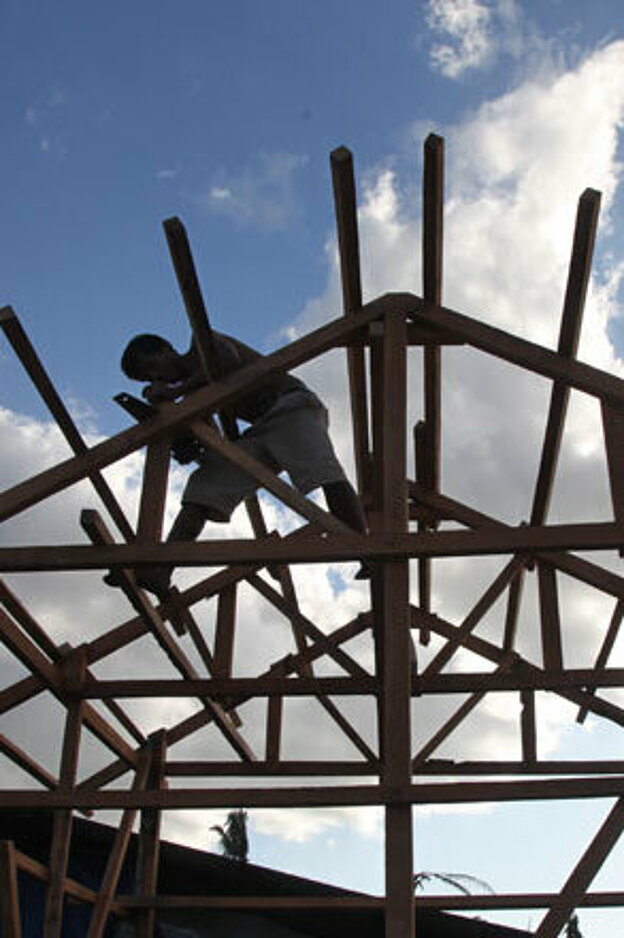 Foto: Handwerker auf dem Holzgerüst eines Daches