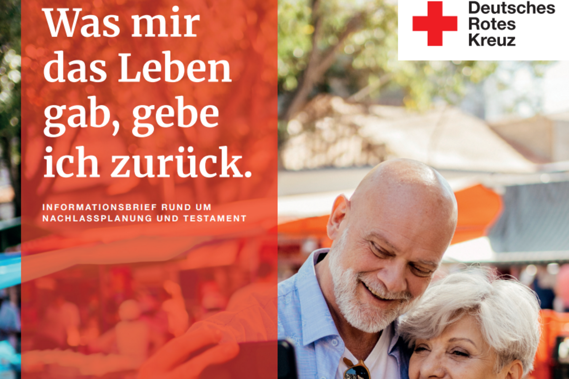Zu sehen ist ein älteres Paar auf einem Markt. Es lächelt, während es ein Selfie vor gefüllten Marktständen macht.