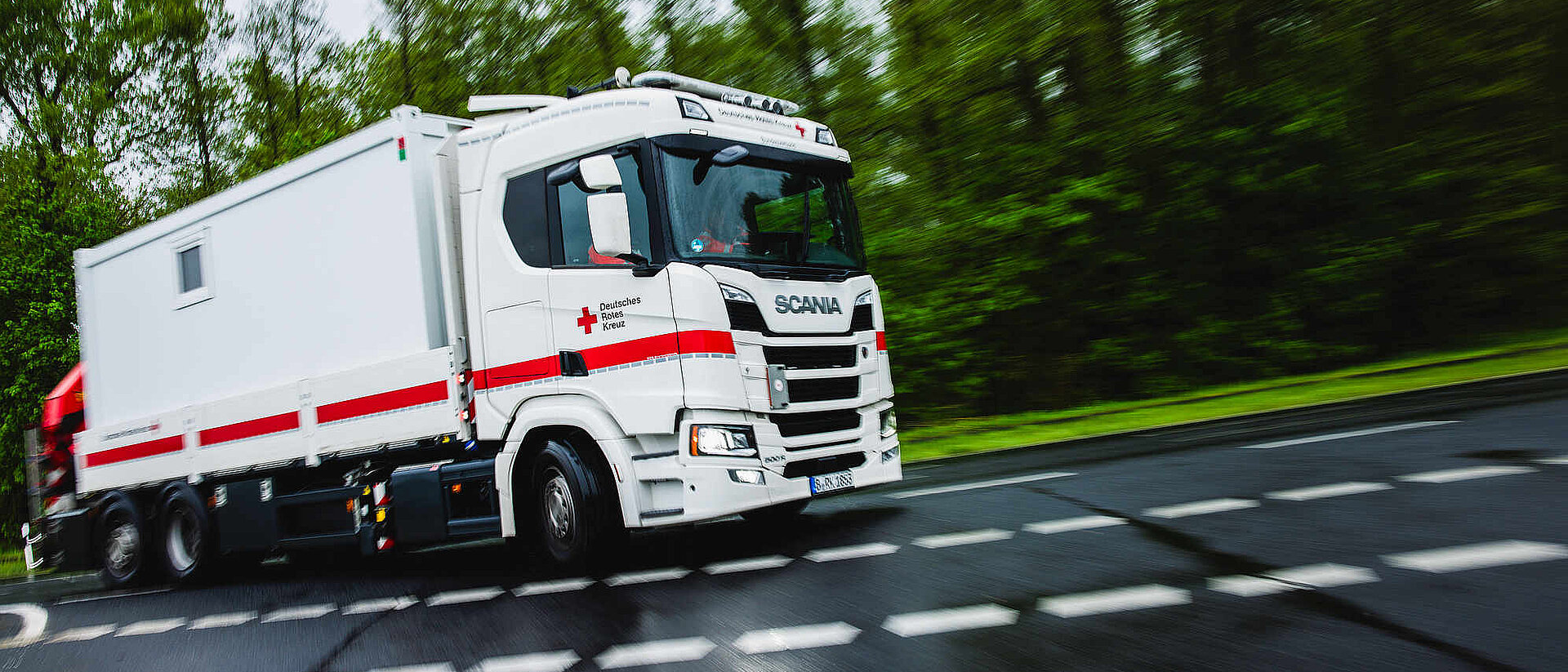 Ein Lastwagen des DRK fährt auf einer Autobahn