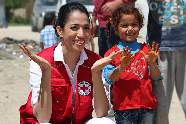 Foto: Zohre Esmaeli und ein syrisches Mädchen zeigen ihre Hände