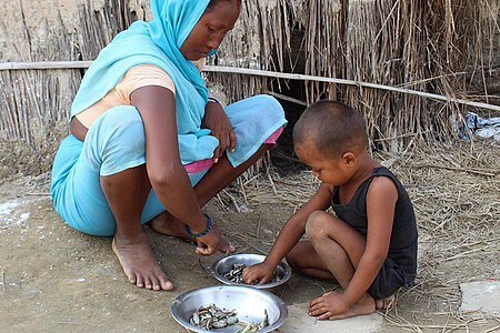 Eine nepalesische Frau und ihr Sohn vor einer Hütte