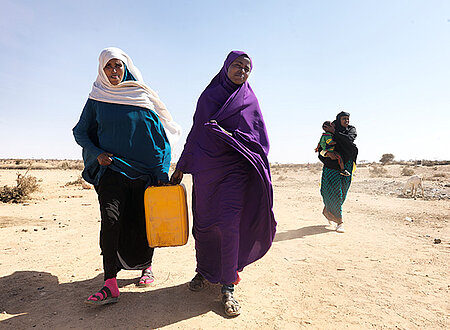 Zwei Somalierinnen tragen einen Wasserkanister