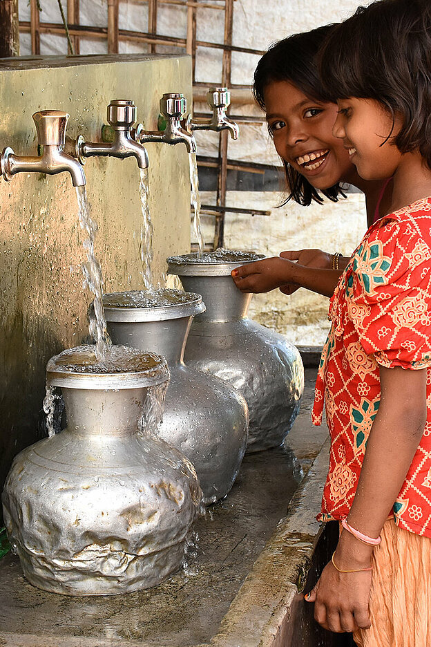 Bangladeschische Mädchen an Wasserhähnen