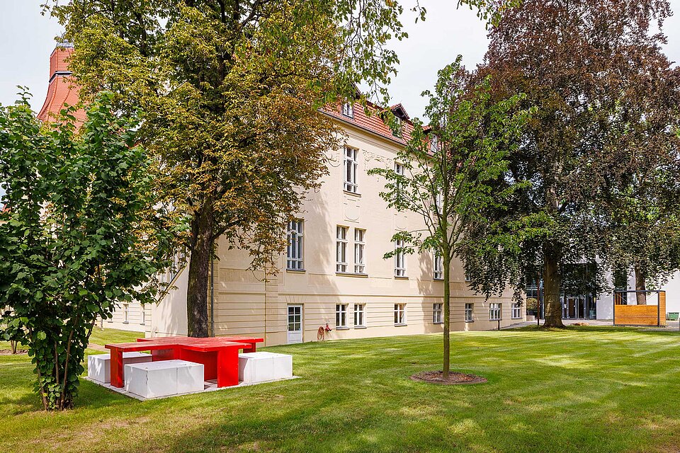 Tisch in Form eines roten Kreuzes vor Gebäude