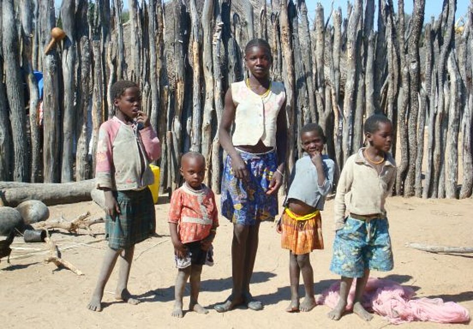 Foto: Eine Gruppe Kinder vor einem Zaun aus knorrigen Ästen