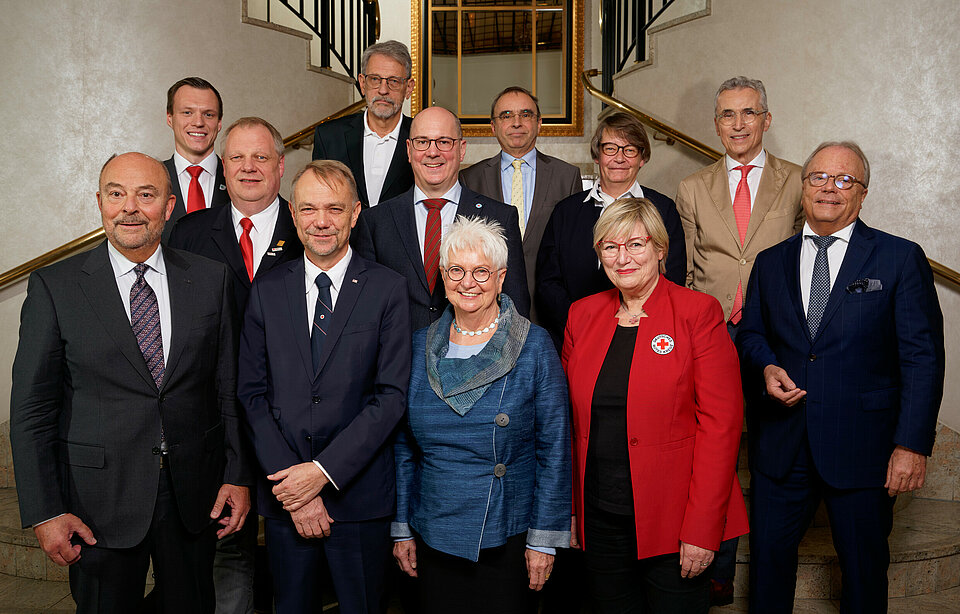 Menschen auf einen Gruppenfoto. Sie sind wie folgt zu sehen: 1. Reihe von li. nach re. Hans Hartmann (Vorsitzender des DRK-Präsidialrats), Vizepräsident Dr. Volkmar Schön, Präsidentin Gerda Hasselfeldt, Vizepräsidentin Ulrike Würth, Bundesarzt Prof. Dr. Bernd W. Böttiger. 2.  Reihe von li. nach re. Martin Bullermann (Bundesbereitschaftsleiter), Andreas Paatz (Bundesleiter Wasserwacht), Gabriele Müller-Stutzer (Generaloberin und Präsidentin des Verbandes der Schwesternschaften vom DRK) 3. Reihe von li. nach re. Marcel Bösel (Bundesleiter Jugendrotkreuz), Prof. Dr. Volker Lischke (Vertreter Bergwacht), Dr. Dieter Weingärtner (Bundeskonventionsbeauftragter), Dr. Norbert C. Emmerich (Bundesschatzmeister) - 20.11.2021