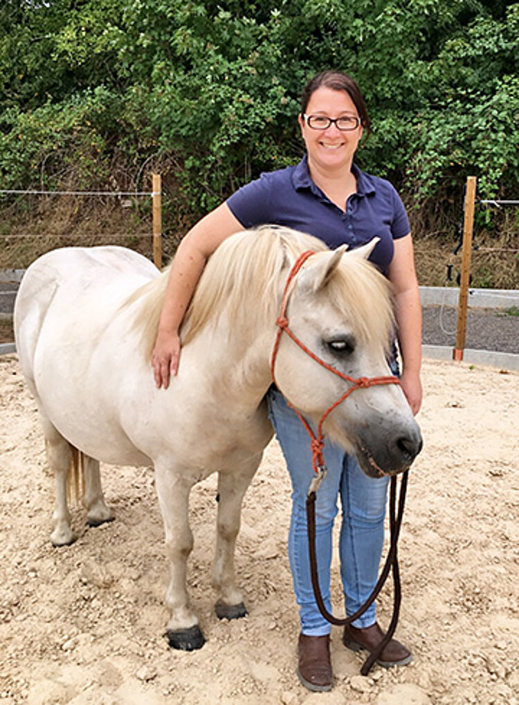 Reittherapeutin mit Therapiepferd auf Reitplatz