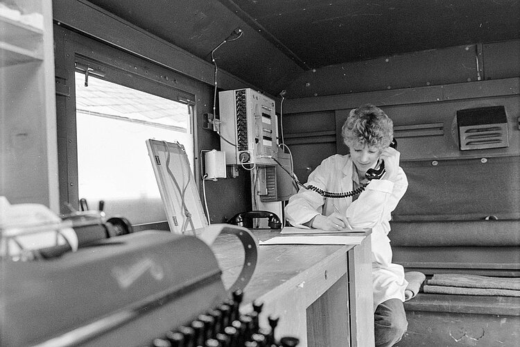 DRKlerin telefoniert im Einsatzwagen