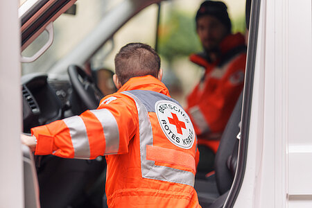 Ein Rettungsdienstmitarbeiter steigt in ein Auto