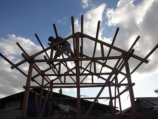 Man working on a wooden roof frame