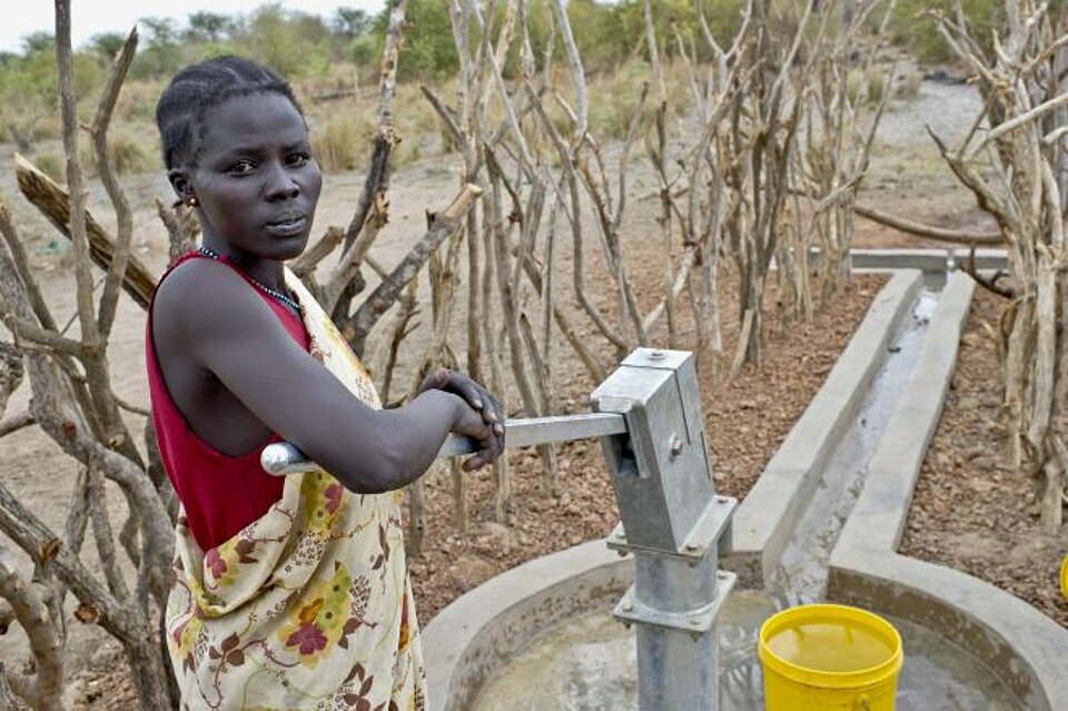 Eine Frau pumpt Wasser ab im Südsudan