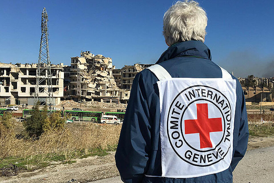 Mitarbeiter des ICRC schaut auf Evakuierungsbusse in Aleppo