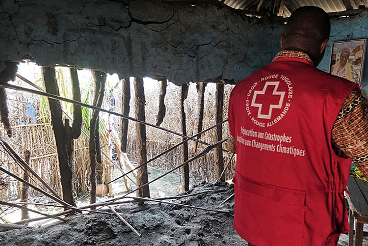 Foto: Togolesischer Rotkreuzler in einem zerstörten Haus