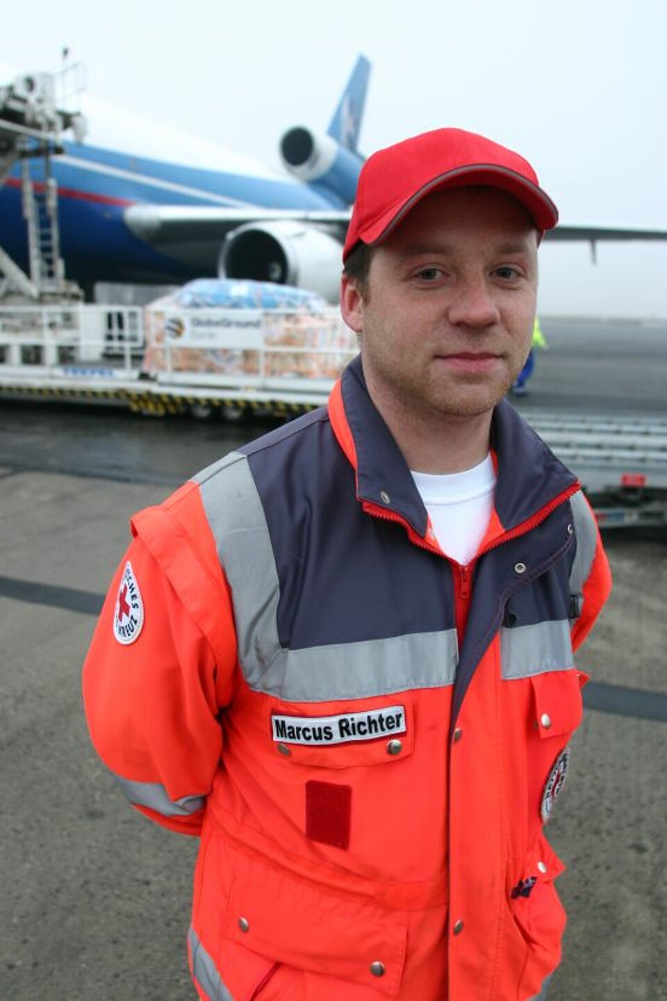 Foto: Marcus Richter in Rotkreuz-Jacke und Rotkreuz-Basecap.