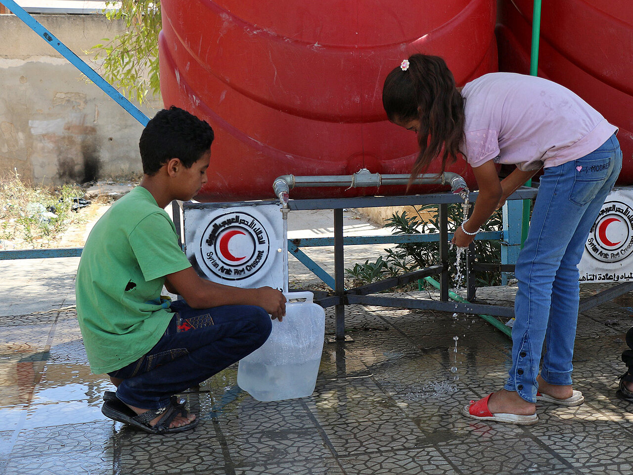 Syrische Kinder an Wasserstelle vom Roten Halbmond 