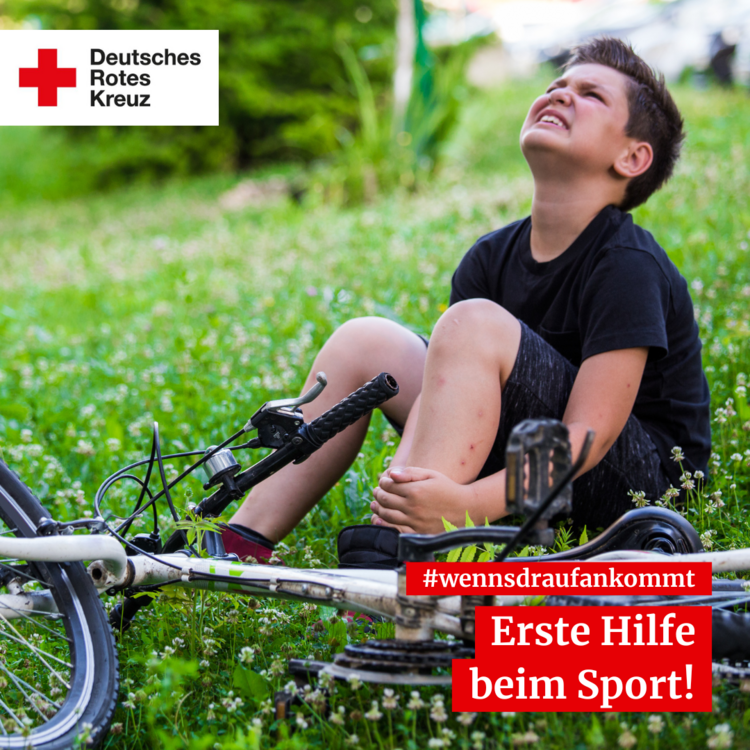 Auf dem Boden sitzendes Kind mit Fahrrad, das sich das Knie vor Schmerzen hält