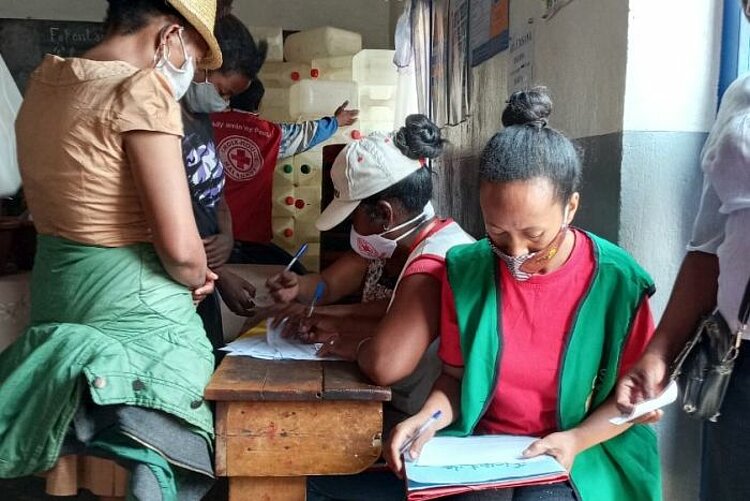 Humanitäre Hilfe in Madagaskar bei Katastrophen: Mitarbeiter des Roten Kreuzes füllen Dokumente aus