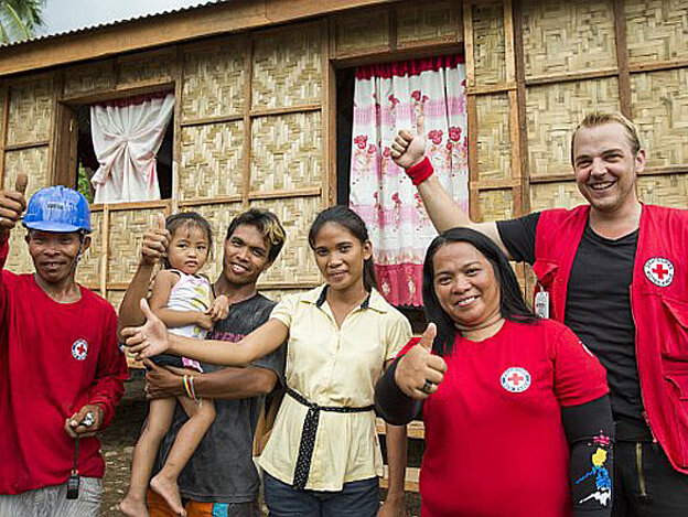 Foto: Philippinische Familie mit Helfern vor einem neuen Bambushaus
