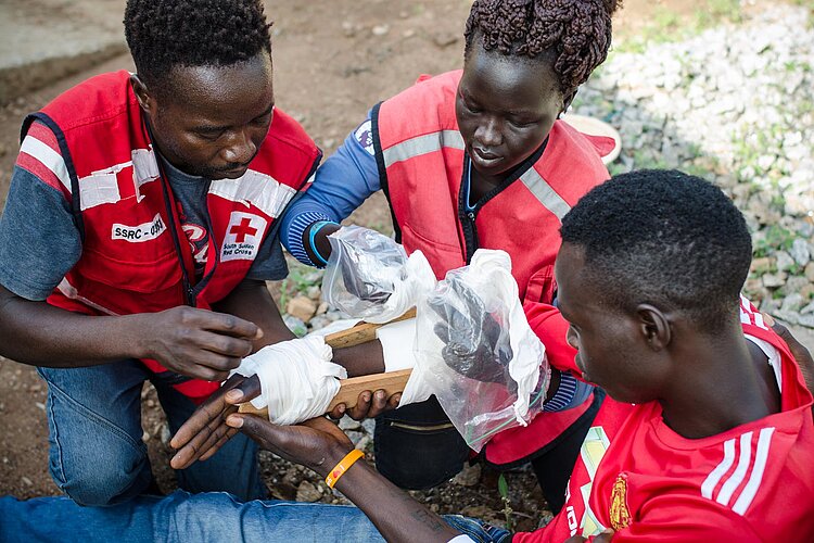 Drei Rotkreuzfreiwillige bei Erste-Hilfe-Übung